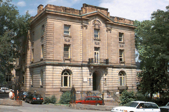 In 1909 James Ross commissioned the famous Montreal architects Edward and William Maxwell to build a house for his son, John Kenneth Leveson Ross, who loved nothing more than horse racing and yachting and managed to spend all of his considerable inheritance by 1935. Ross's house, located across from his father's on Peel Street, shows a trend towards a more austere, symmetrical, Classical style, prevalent in the early twentieth century. This abode, although supported by a steel frame, hides its modernity beneath a symmetrical, Edwardian Baroque style facade. Colossal Ionic pilasters, supporting a broken pediment, emphasize the centre and entrance of the building as does the balcony protruding over the door. As with many Classical edifices, the fenestration becomes less embellished with each ascending floor. The interior features several elegant oak paneled rooms, many of which have intricate plaster details on the ceiling. Marionopolis College bought the house in 1961 for CEGEP administration. In 1976, McGill purchased the house and named it the J.K.L. Ross house. Today it is occupied by the Institute and Centre of Air and Space Law.