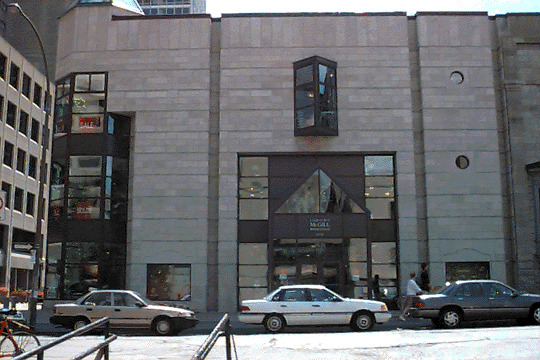 Over the years, the McGill Bookstore has had several homes, including a house that once existed on the site where McConnell Engineering stands today. In 1990, the University commissioned the firm of Werlman and Guy to build a permanent edifice for the Bookstore on McTavish Street. This three-storey building has a concrete frame that is faced with Montreal limestone in keeping with the rest of the campus. In its size, shape, colour, and placement, the Bookstore blends with the neighboring structures and continues the facade of McTavish Street in a contemporary manner. The entrance and the southeast corner are enclosed in glass and serve as excellent display areas. The bookstore is now located in the campus store on Sherbrooke.